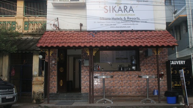 A building with a sign for 'Sikara Hotels & Resorts' and a brick facade. - Hotel Sikara Kumbakonam (Kumbakonam)