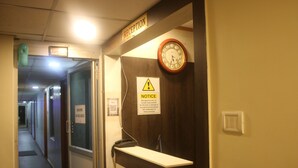 A reception area with a clock, a notice board, and a sign indicating rooms are available. - Hotel Sikara Kumbakonam (Kumbakonam)