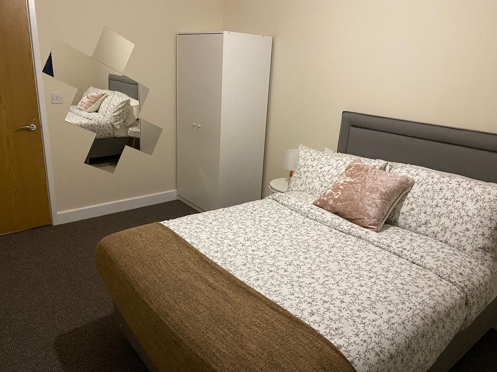 Ein Hotelzimmer mit Bett, Kleiderschrank und Spiegel.