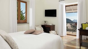 A hotel room with a bed, a desk, a TV, and a balcony with a view. - Villa Donatella, Ideal For Large Groups (Massa Lubrense)