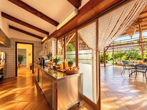 A kitchen with a wooden ceiling, a large window, and a dining area with outdoor seating. - Villa Donatella, Ideal For Large Groups (Massa Lubrense)