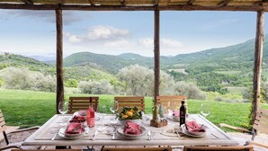 Une table dressée pour un repas, avec une vue imprenable sur les montagnes.
