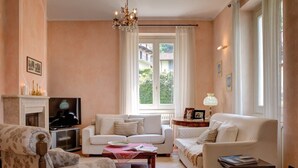 Una sala de estar con chimenea, dos sofás, una mesa de centro y un televisor.