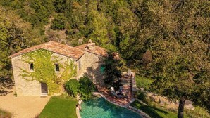 A stone house with a swimming pool, surrounded by lush greenery and trees. - Villa Anselma - Private Villa with Pool (Umbertide)