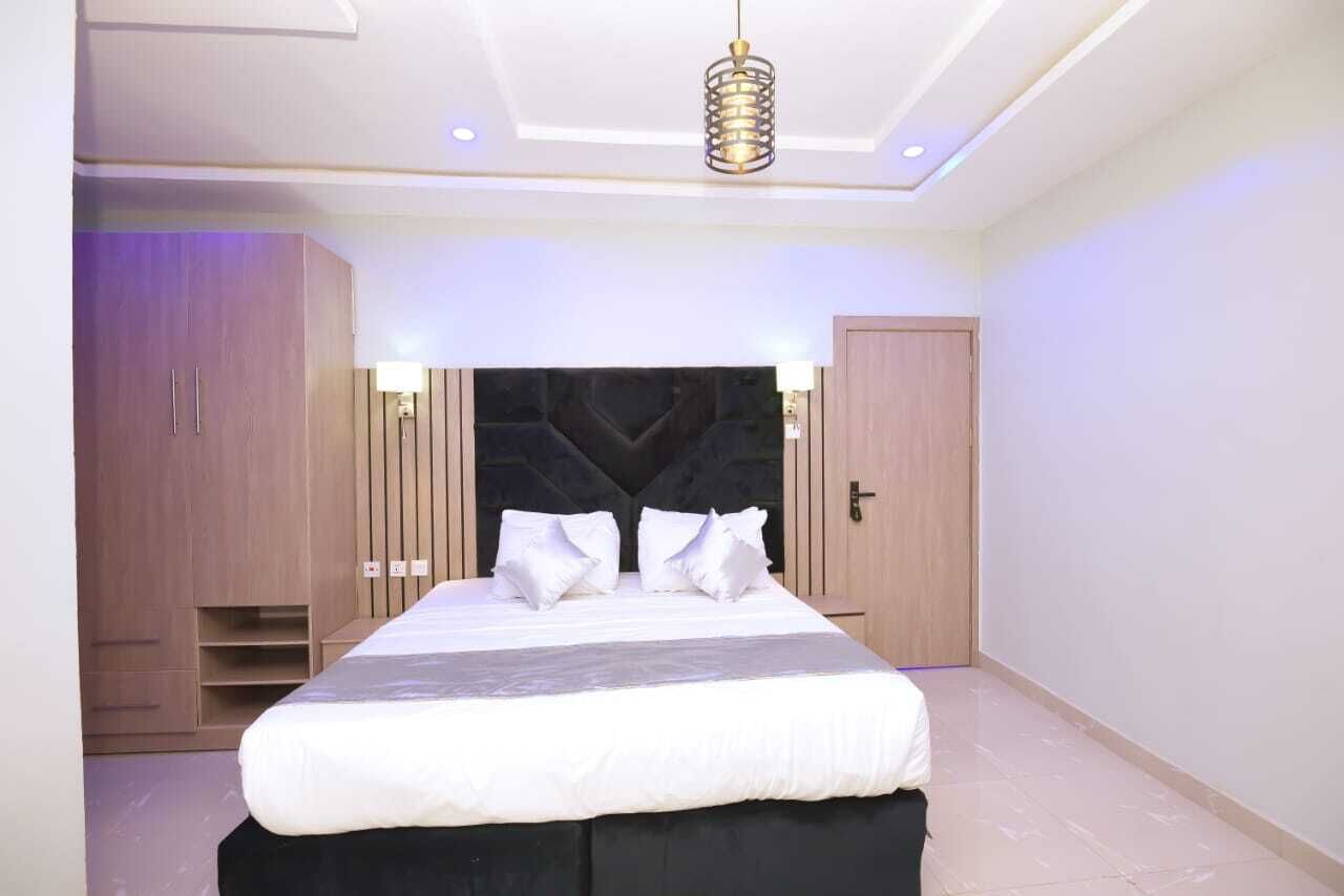 Un dormitorio con una cama grande, cabecera y armarios empotrados.