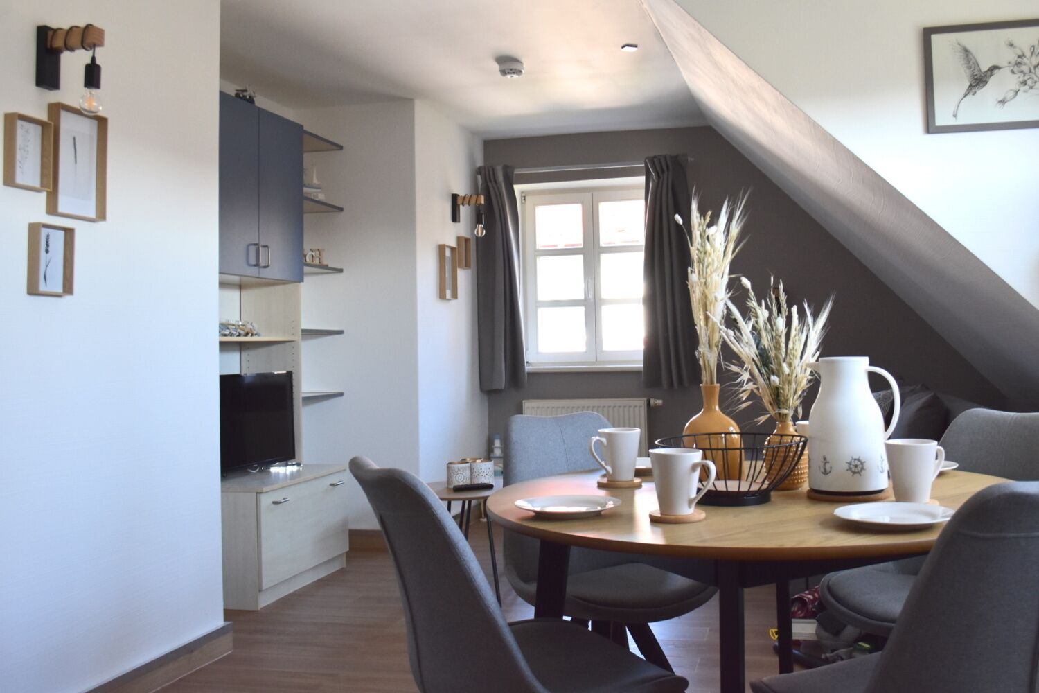 Un espace repas comprenant une table ronde, des chaises et un coin café.