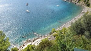 A coastal view with clear turquoise waters, boats, and a rocky shoreline with greenery. - Stella Di Mare, with pool and sea views (Positano)