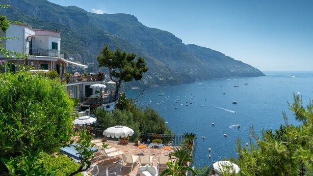 A coastal property with a terrace overlooking the sea, featuring outdoor seating and a view of boats. - Stella Di Mare, with pool and sea views (Positano)