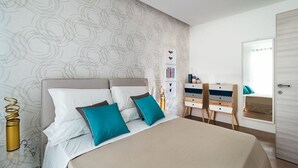 Une chambre à coucher moderne, avec un lit, deux tables de chevet, une commode et un miroir.