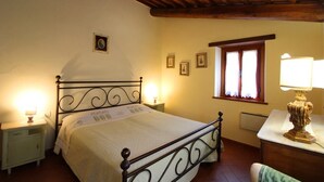 A bedroom with a bed, bedside tables, a window, and a lamp.