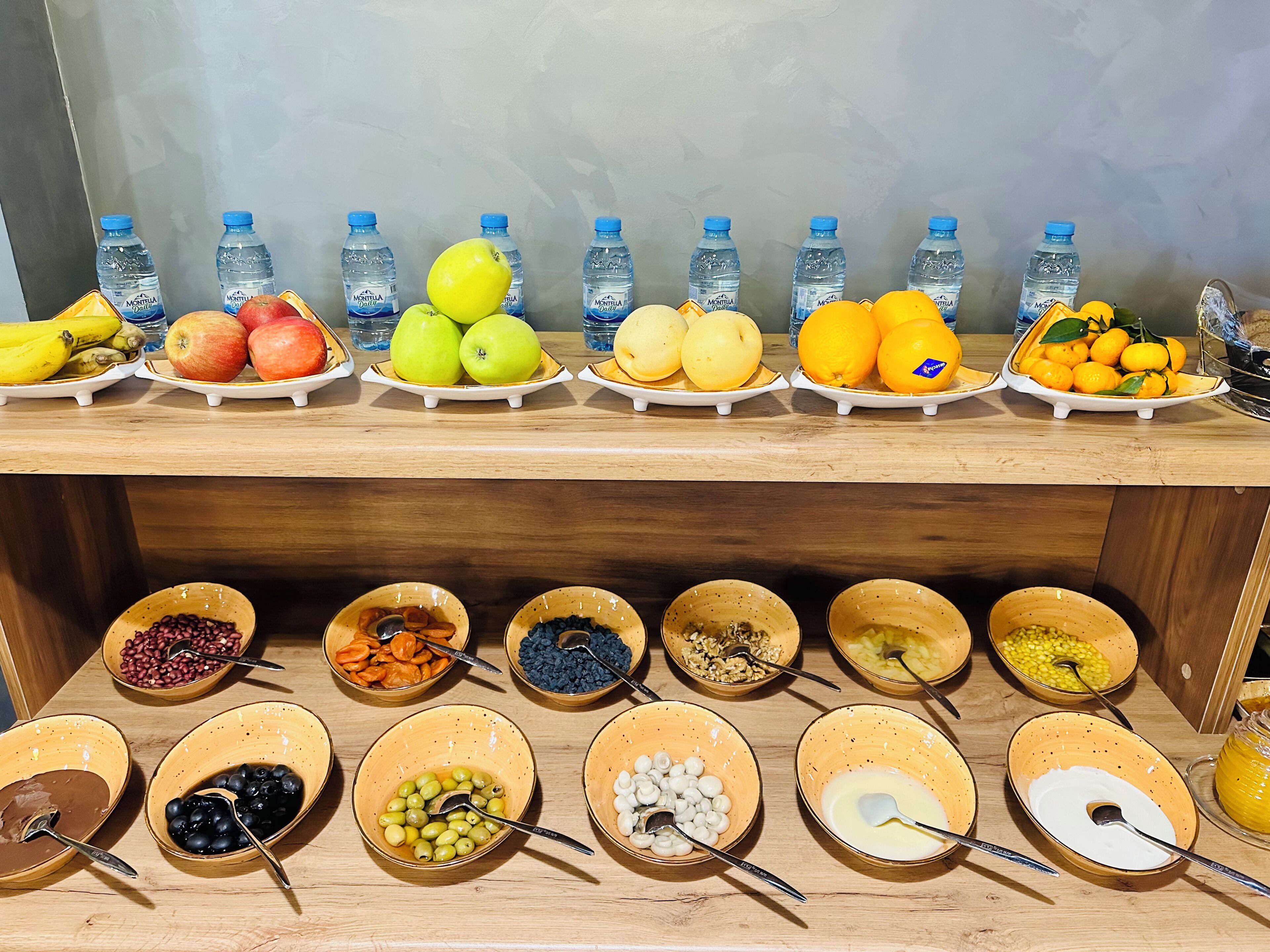 A buffet table with various fruits and beverages.
