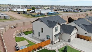A residential area with houses, a driveway, and a fenced yard with a patio. - Spacious 5-BR Home: Private Hot Tub & Big Yard, Stocked Kitchen, Mountain View! (Colorado Springs)