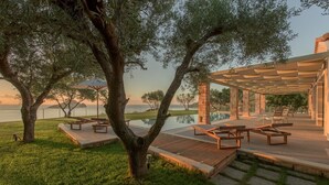 A serene outdoor area with a pool, wooden deck, and lounge chairs. - Villa Zenais, Luxury with swimming pool (Koridallos)