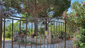 A wrought iron gate with a stone wall and a sign reading "Reception". - Villa Castagna Dans un Splendide Parc Fleuri, Calme à 900 m de la Plage (Calvi)