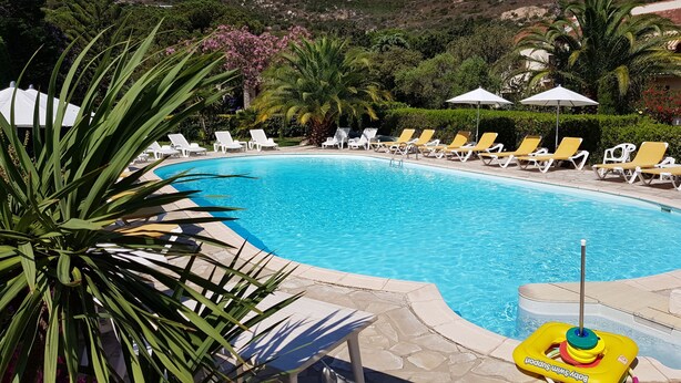 A swimming pool with sun loungers and a water filtration device. - Villa Castagna Dans un Splendide Parc Fleuri, Calme à 900 m de la Plage (Calvi)