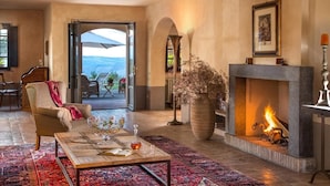 Una sala de estar acogedora con chimenea, un ventanal y vistas al exterior.