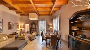 A cozy living room with a wooden ceiling, a dining area with a table set for four, and a bookshelf with decorative items. - Casa Mordigallina, in Sorrento Centre (Sorrento)