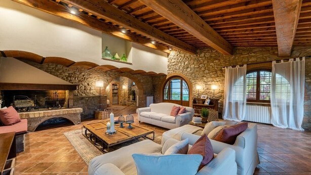A cozy living room with stone walls, wooden beams, a fireplace, and comfortable seating. - Villa Biancospino - Private Villa with Pool (Chianni)