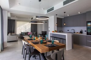 Enjoy meals in this stylish dining area with a modern kitchen and comfortable seating.