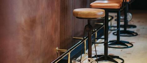 A bar area with a counter labeled 'greet' and several bar stools.