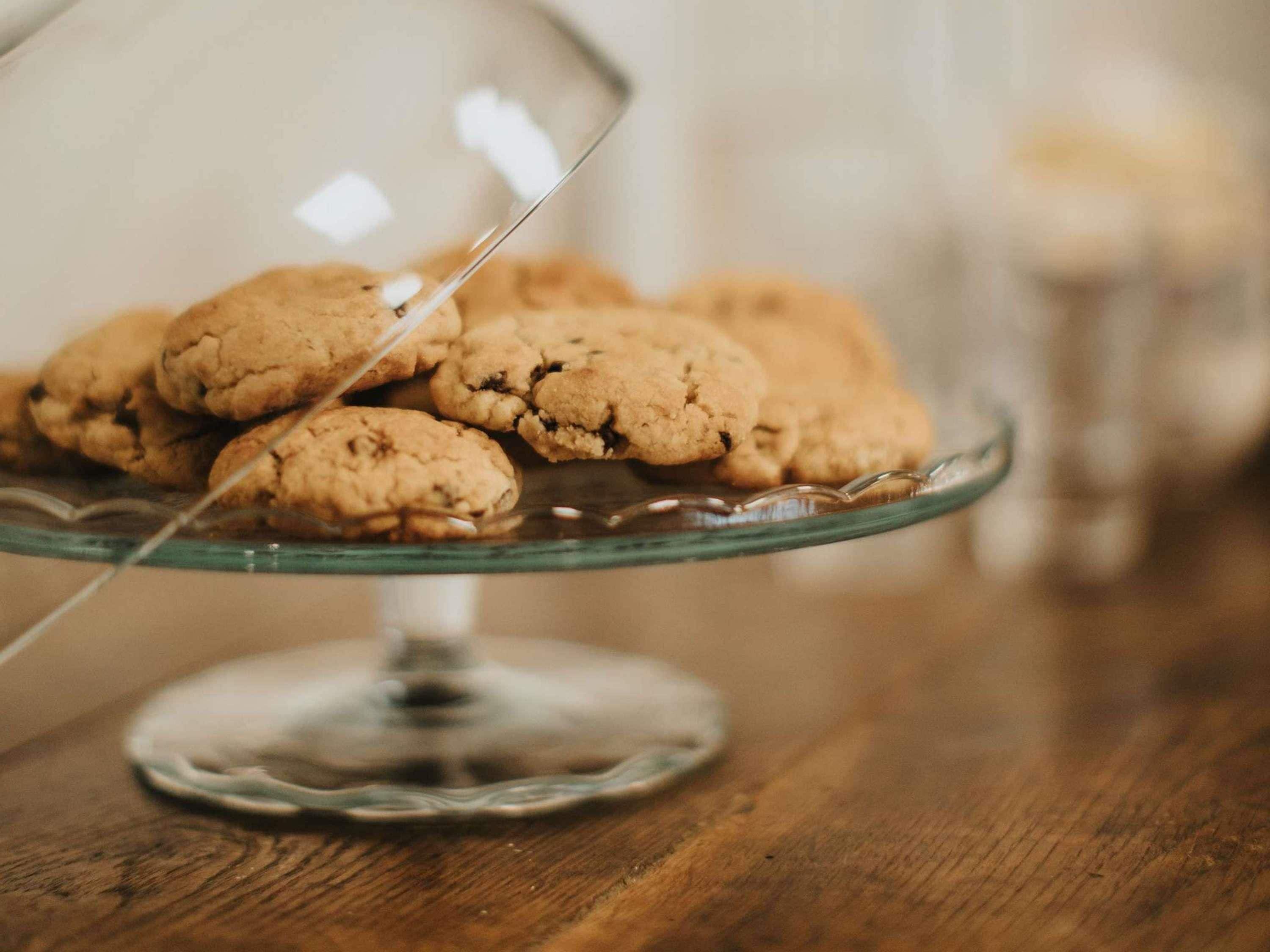 Une assiette en verre contenant des biscuits, posée sur une table en bois.