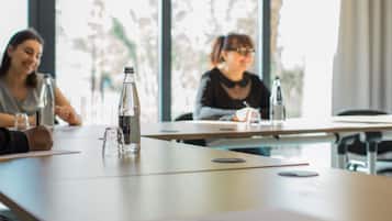 Una sala de reuniones con una mesa, una botella y una taza.