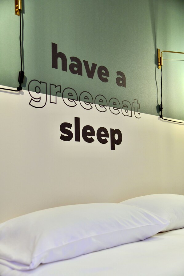 A bed with a wall-mounted sign that reads "have a great sleep."