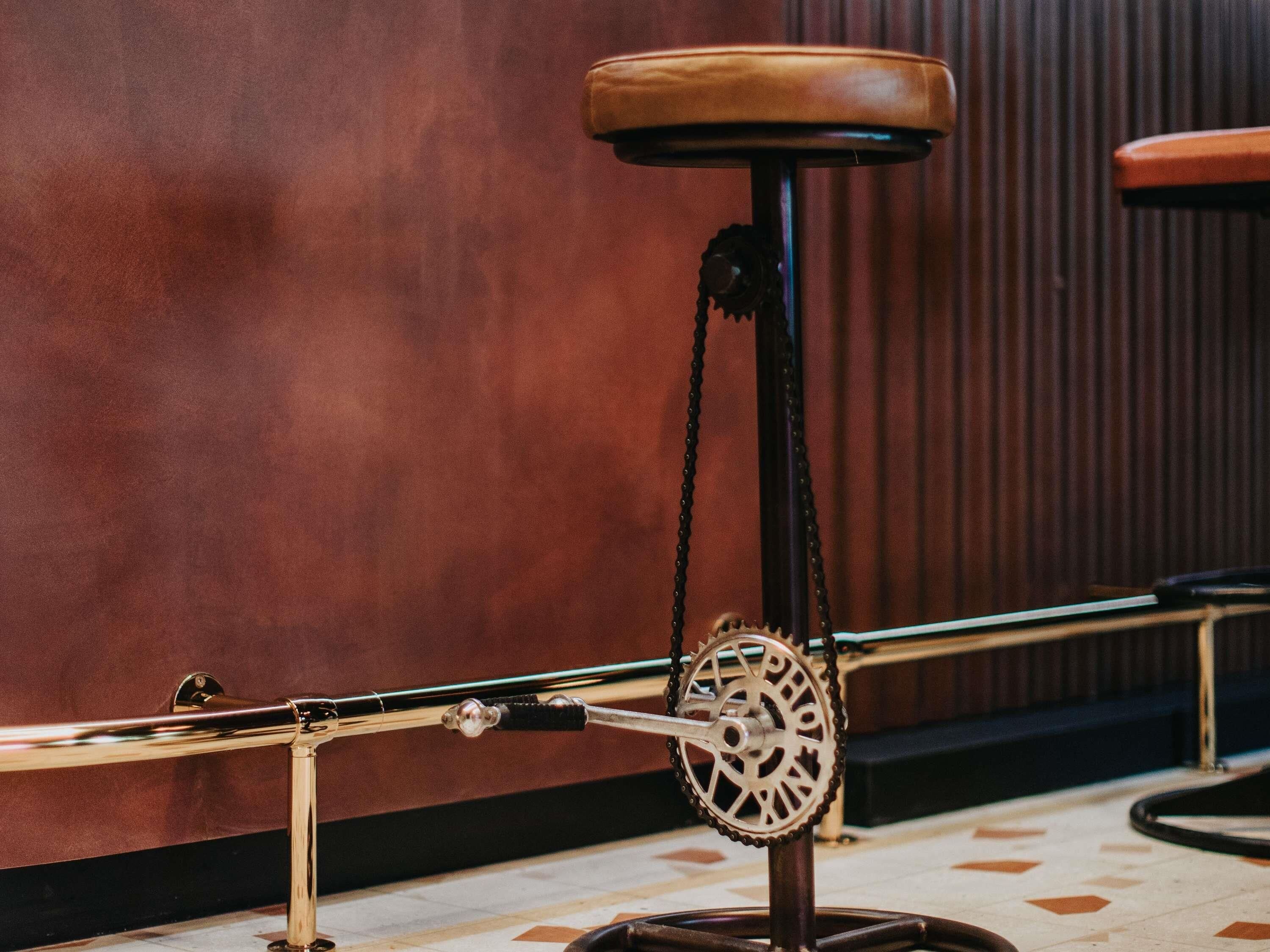 Un taburete de bar con asiento de cuero y estructura metálica.