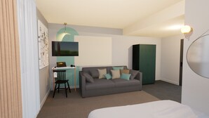 A modern hotel room with a grey sofa, a small desk with a laptop, a green wardrobe, and a large mirror. - Greet Hotel Brest Aéroport (Guipavas)