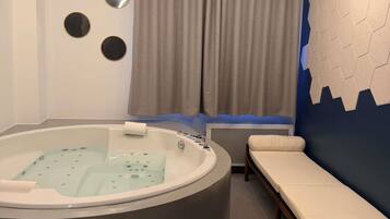 A modern bathroom with a bathtub, a vanity, and a bench.