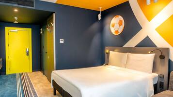 A modern hotel room with a bed, a yellow door, and a unique wall design.