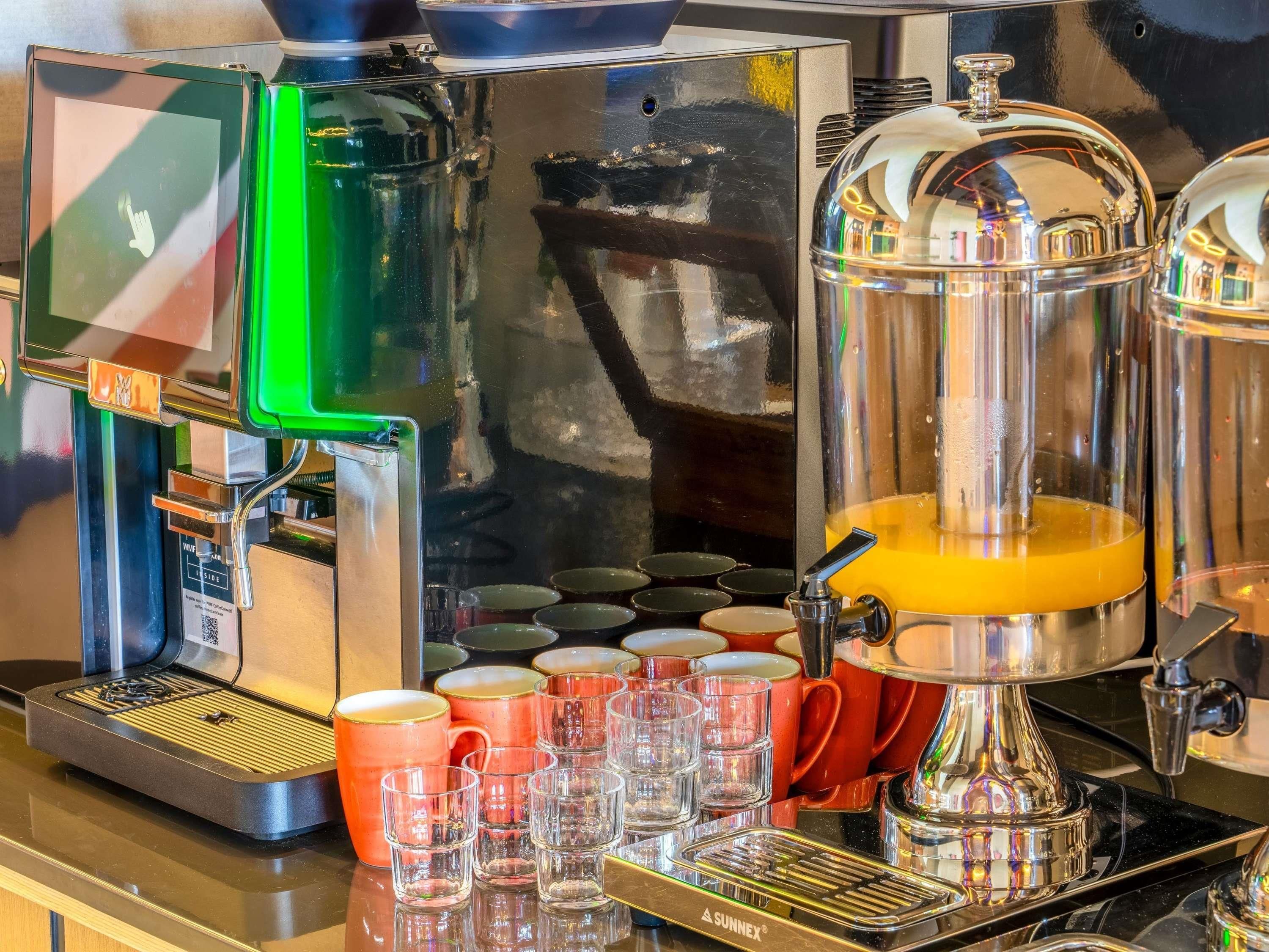 A coffee machine with a digital display, a milk frother, and a coffee press.