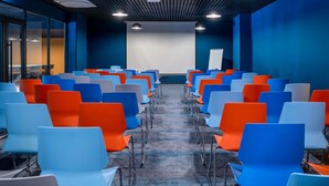 A conference room with rows of chairs, a projector screen, and a whiteboard. - ibis Styles Batumi  (Batumi)
