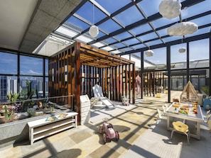 Un espacio interior amplio con techos altos, ventanas grandes y vistas a la ciudad.