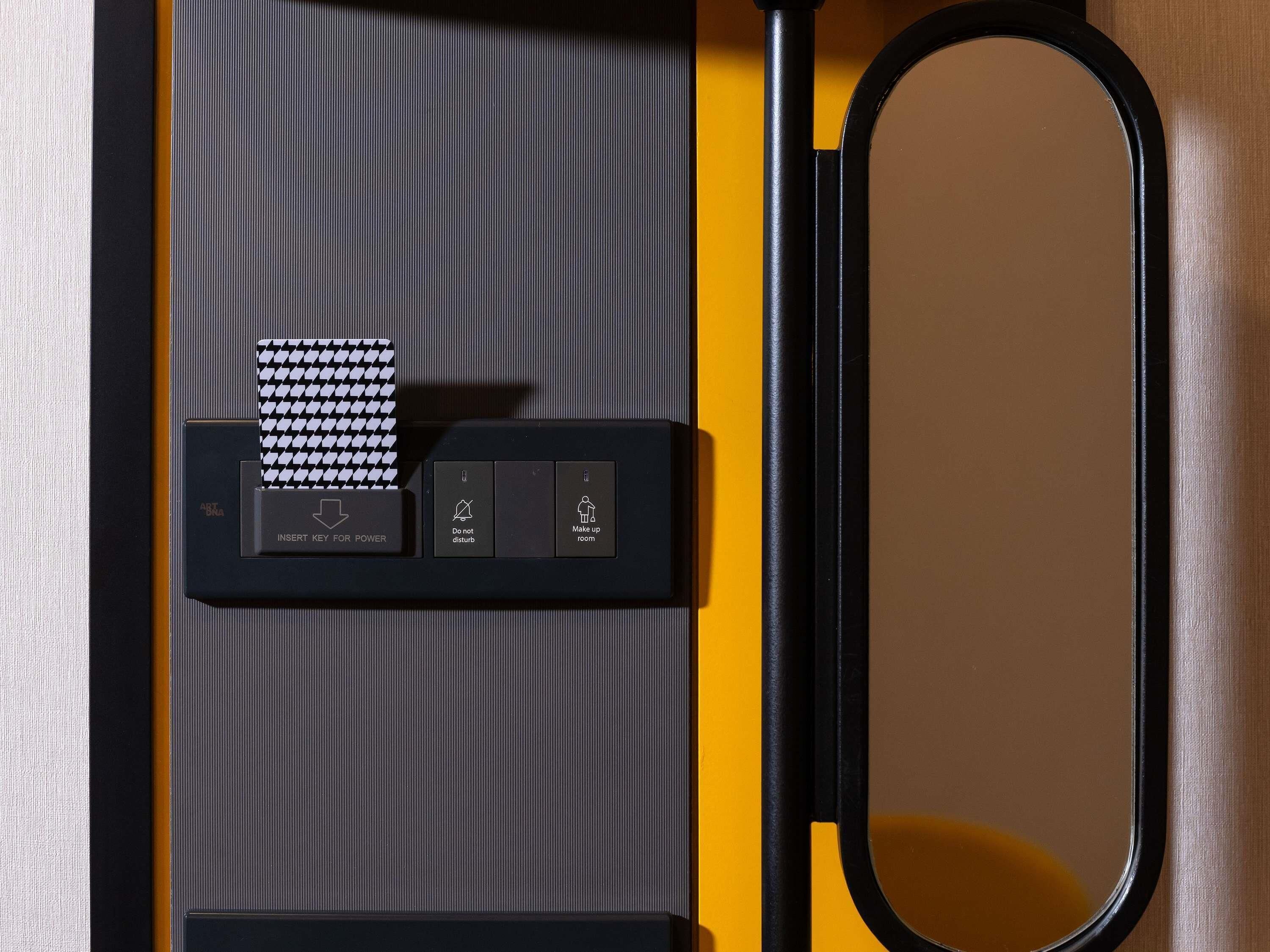 A black and yellow room with a mirror, a black key for power, and a houndstooth-patterned card.