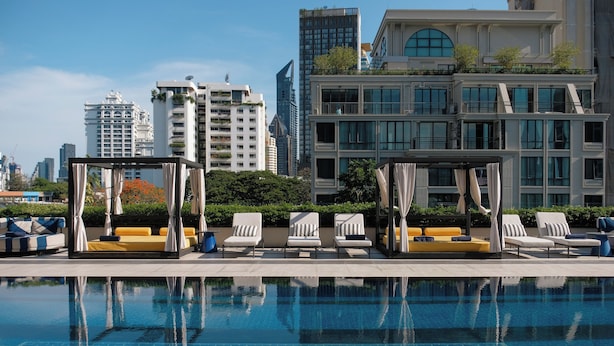 A rooftop pool with lounge chairs and a cabana, surrounded by modern buildings and a clear sky. - TRIBE Living Bangkok Sukhumvit 39 by AccorHotels (Bangkok)