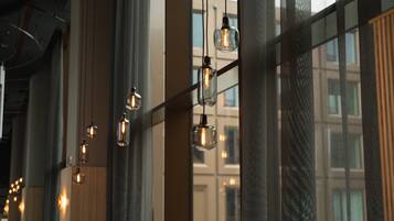 Un intérieur moderne agrémenté de luminaires suspendus et de grandes fenêtres.