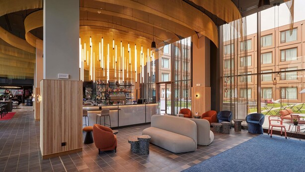 A modern lobby with a bar area, seating, and large windows. - Tribe Milano Malpensa (Vizzola Ticino)