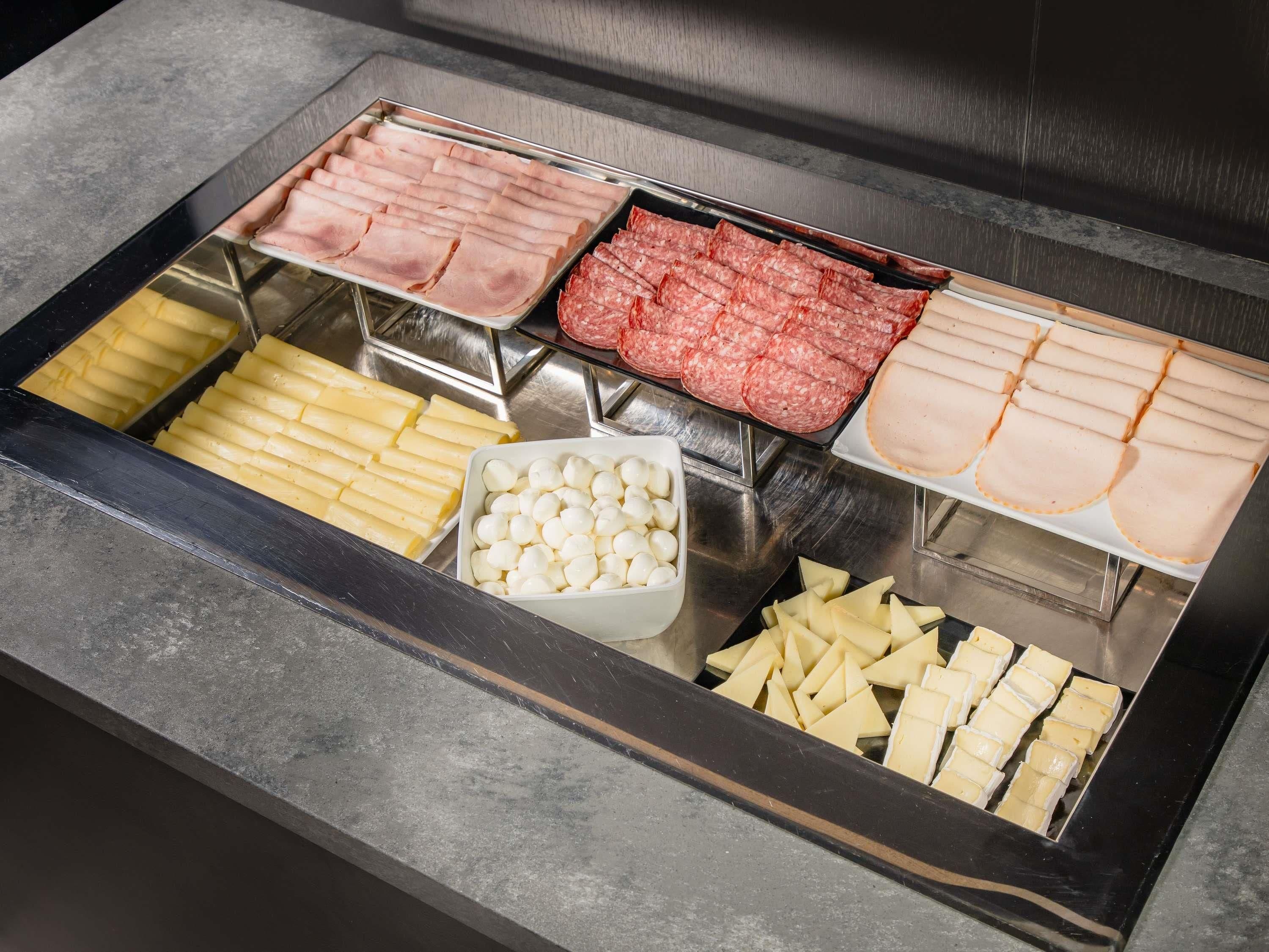 A food display with various types of meat and cheese.