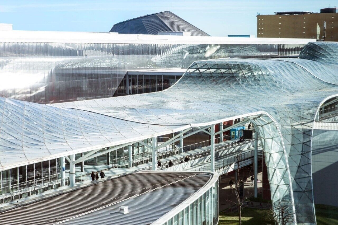 A modern building with a curved glass roof and a spacious interior.