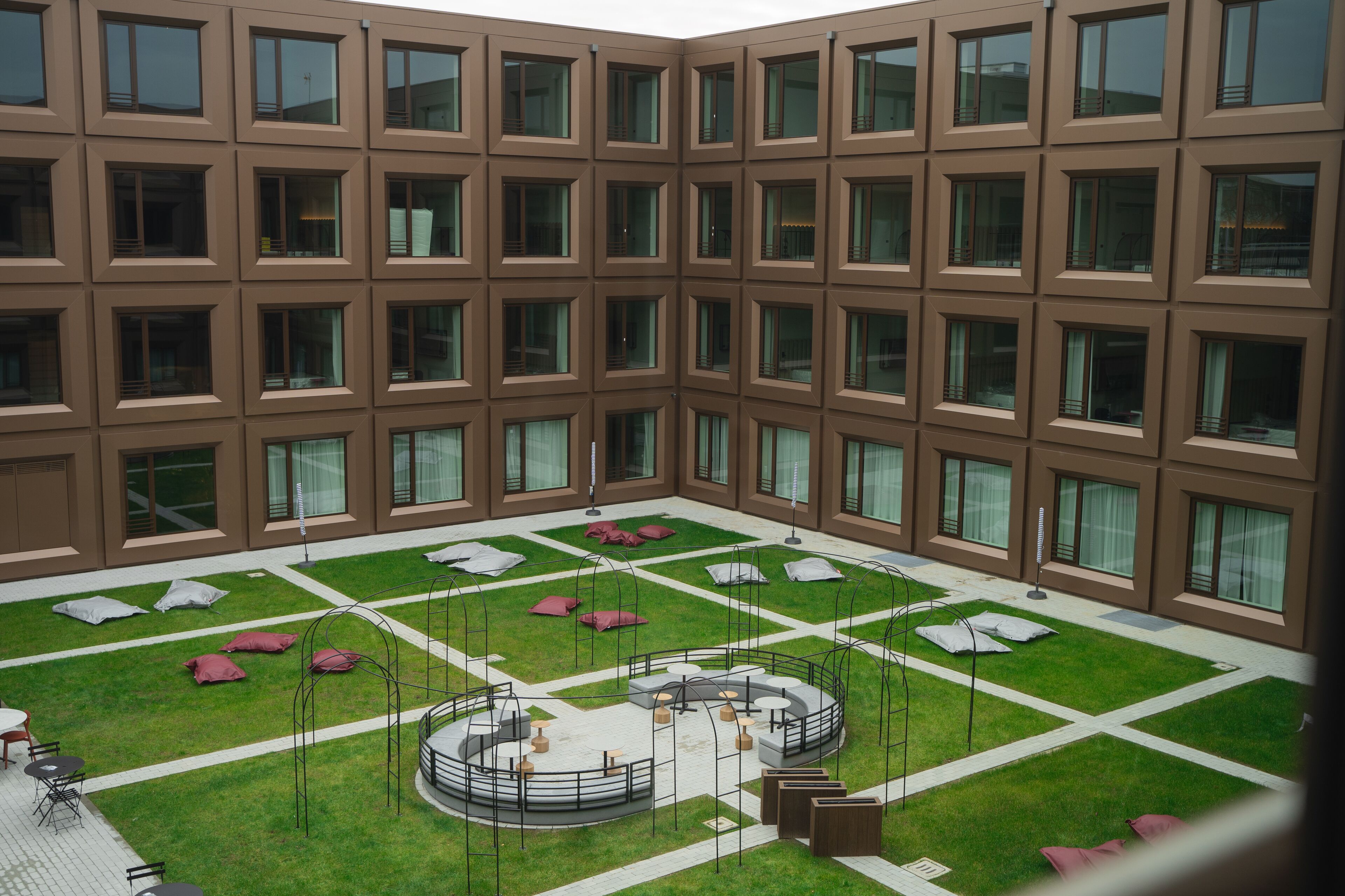 A courtyard with a central seating area, surrounded by a building with multiple windows.
