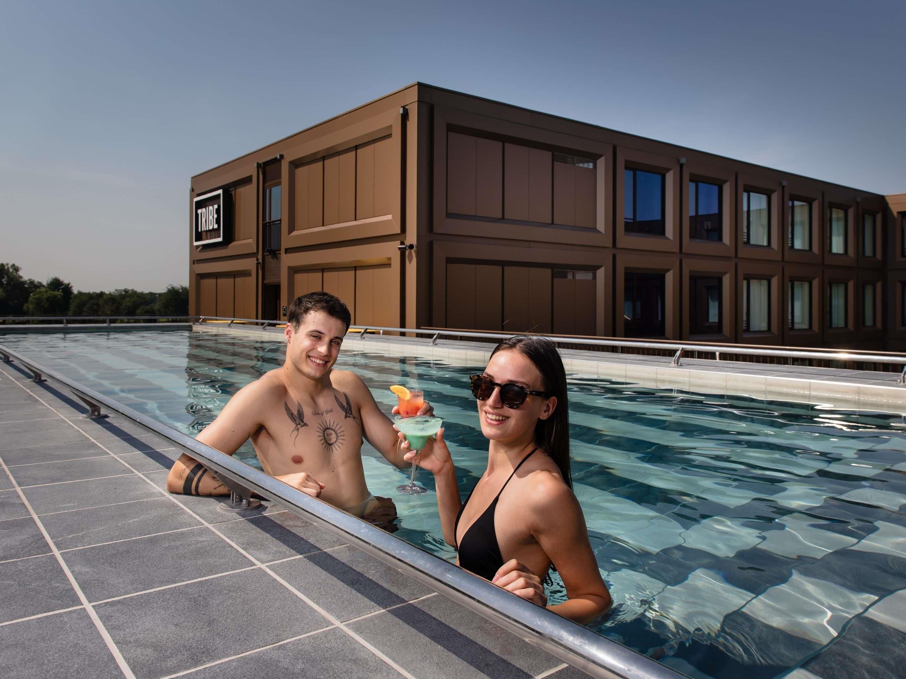 Una piscina con un edificio moderno al fondo.