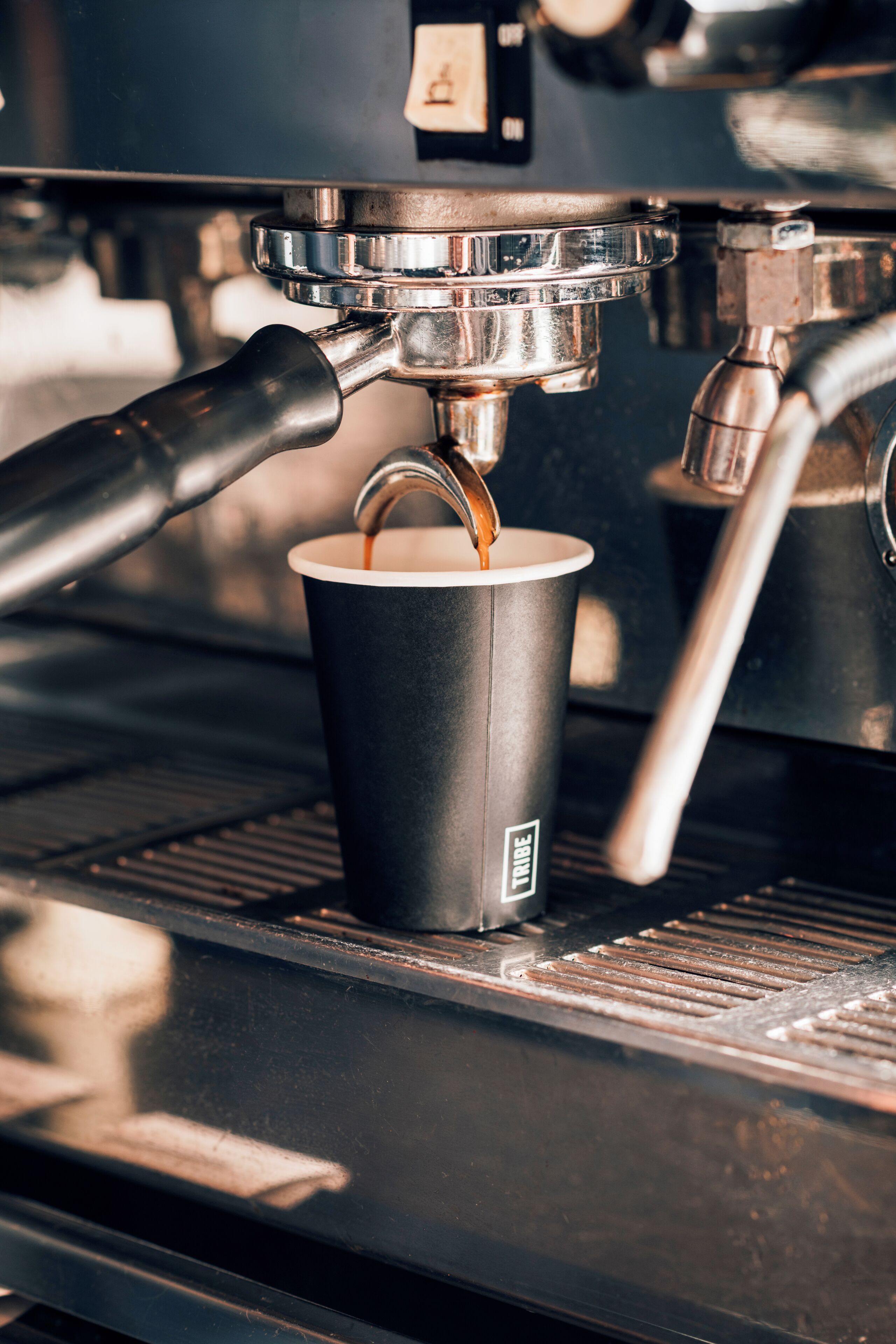 A coffee machine dispensing coffee into a paper cup.