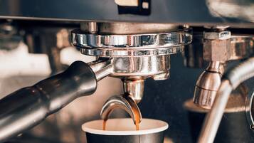 Une machine à café qui verse du café dans un gobelet en papier.