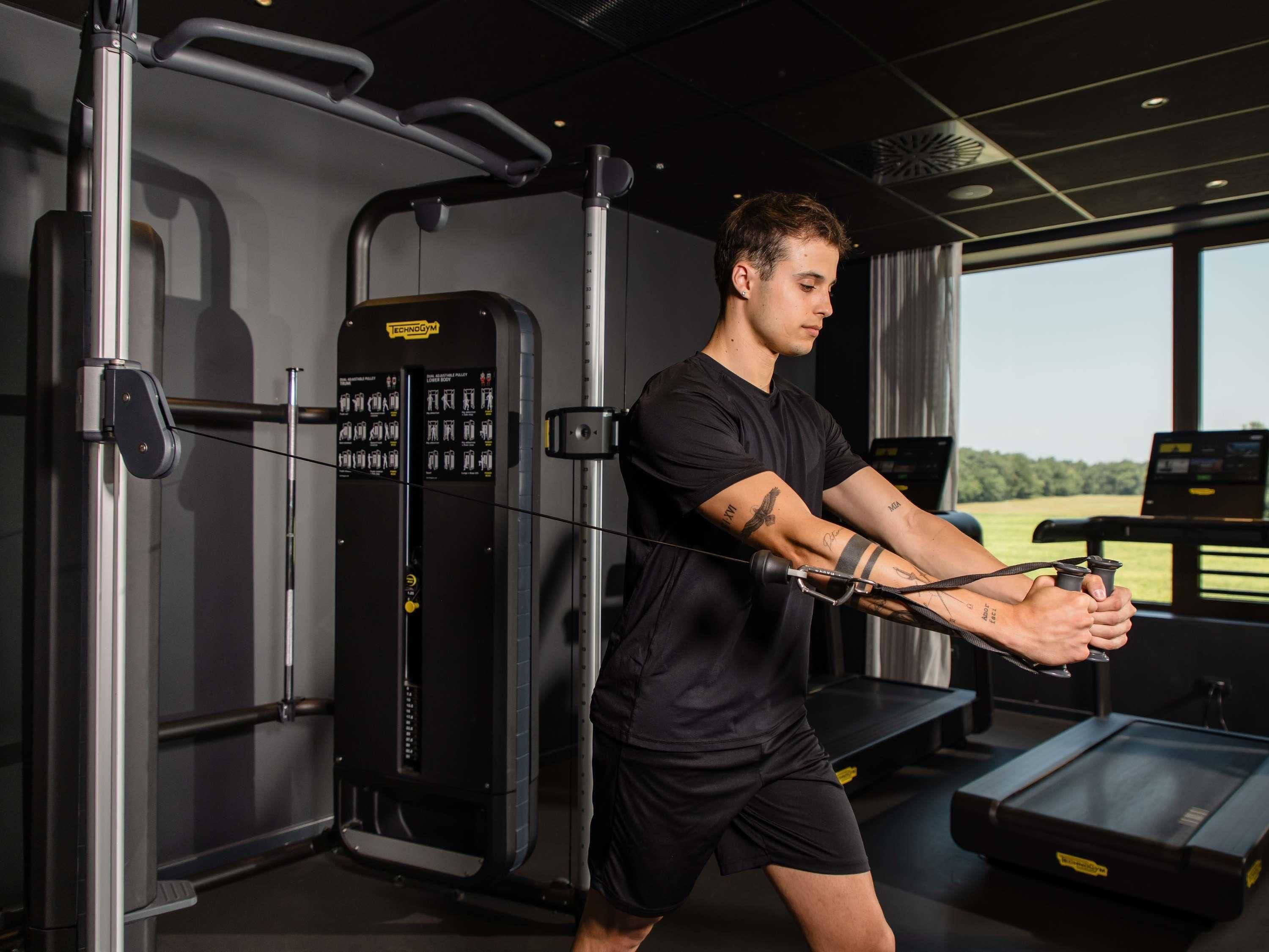 A gym with exercise equipment, a treadmill, and a view of the outdoors.