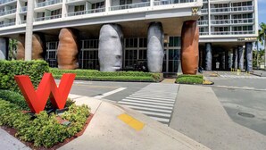 A modern hotel with a distinctive architectural design featuring large, cylindrical columns and a prominent red 'W' logo. - ICON W BRICKELL LUXURIOUS OCEAN VIEW 2BR/2BA #3002 (Miami)