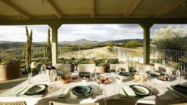 Une table dressée pour le repas, offrant une vue panoramique sur les montagnes et la verdure.