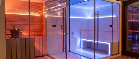 A modern sauna with glass walls, wooden benches, and a wooden floor.