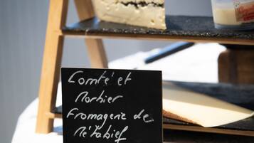 Un cartel de pizarra con el texto 'Comté et Norbier Fromagerie de Neufchâteau' que indica una tienda de quesos.