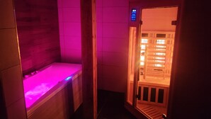 A sauna room with a wooden bench and a digital control panel. - Luxury residence in Métabief, suites, apartments, private spa and sauna (METABIEF)